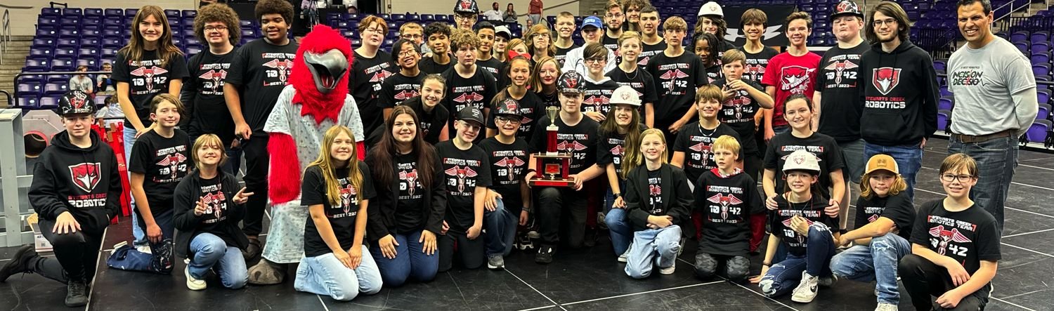 The team celebrating a BEST Award win with the red hawk mascot